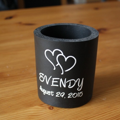 Ein Getränkedosenhalter, darauf gedruckt zwei ineinander verschränkte Herzen und der Text: Svendy, August 29, 2015