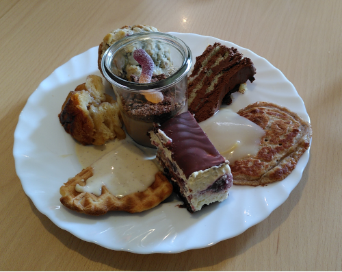Gemischter Büffetteller mit Desserts: Doonauwelle, Pudding im Glas, ein Waffelherz, ein kleiner Pfannkuchen, jewiles mit Vaillesauce, ein Stückchen Apfelkuchen, ein StückchenSchokoladenkuchen und ein Muffin