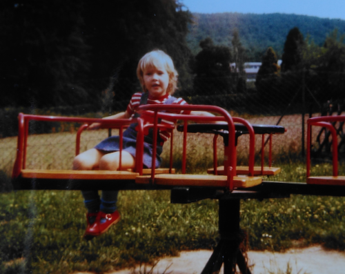 mein jüngeres Ich: ein Photo aus den siebziger Jahren zeigt ein etwa vierjähriges blondes Mädchen auf einem Spielplatzkarussell