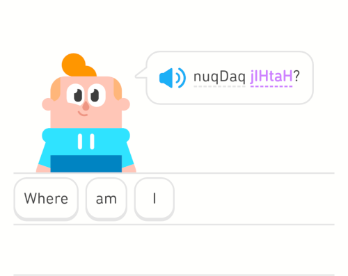 Screenshot von Duolingo. Eine Cartoonfigur mit einer Sprechblase, in der Worte auf klingonisch stehen. Darunter die Übersetzung auf Englisch: Where am I?