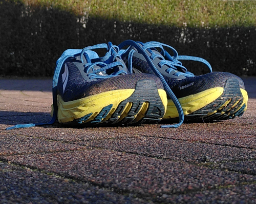 Nahaufnahme von zwei blauen Laufschuhen mit gelber Sohle