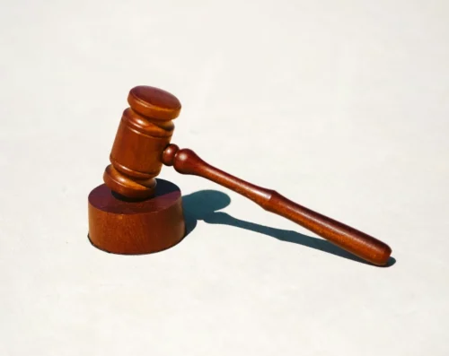 A wooden gavel on a white table for the short story challenge February 2025