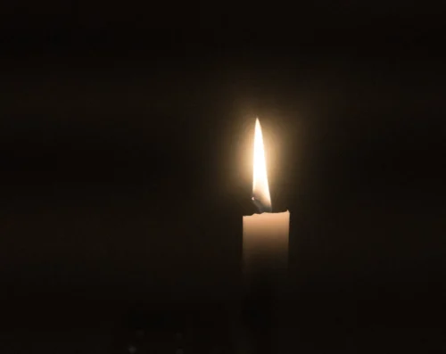 photo of a burning candle in the dark, for the story challenge march 2025