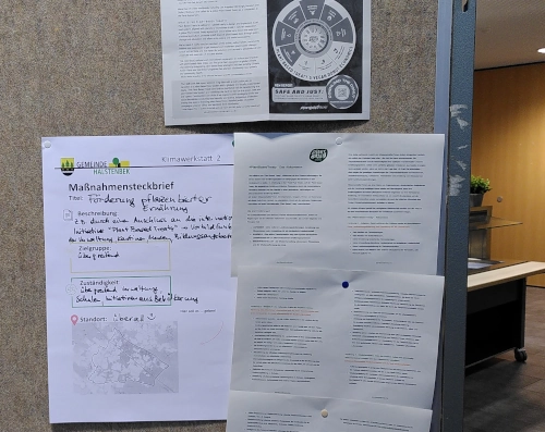 Nahaufnahme von DIN-A4-Blättern an einer Pinnwand. Darauf sind Vorschläge zur Inspiration der Bevölkerung Halstenbeks zu mehr pflanzlicher Ernährung