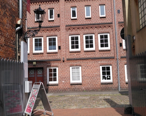 Photo aus einer Einfahrt heraus auf rote Ziegelsteinhäuser