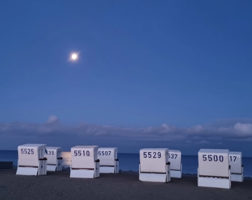Photo von weißen Strandkörben in einer Vollmondnacht