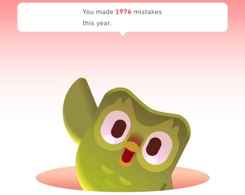 Screenshot aus Duolingo, eine kleine Cartooneule taucht aus einem Loch im boden auf und winkt. Darüber steht You made 1976 mistakes this year.
