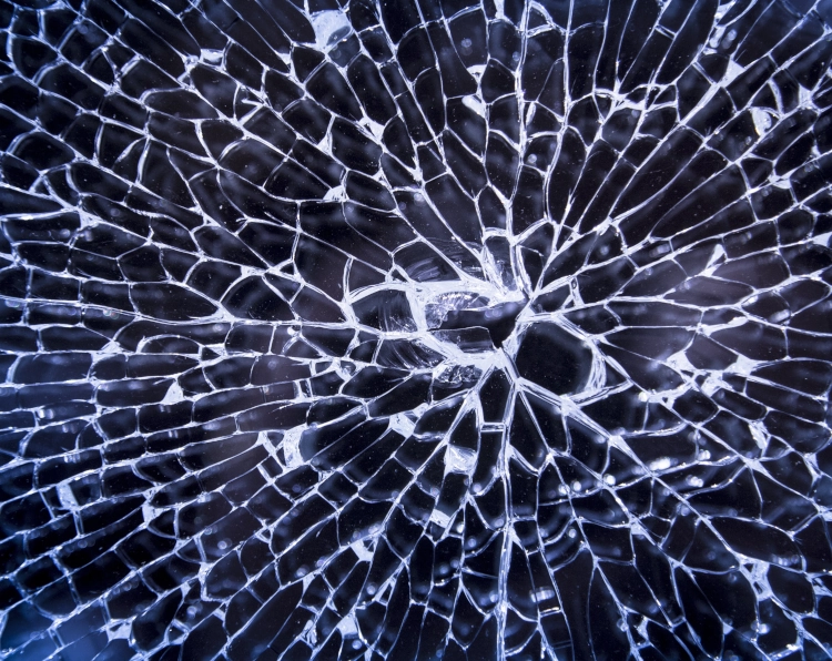 cracked glass in front of a dark background