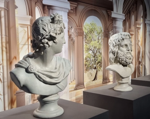 Zwei weiße Büsten von grecoromanischen Gottheiten.