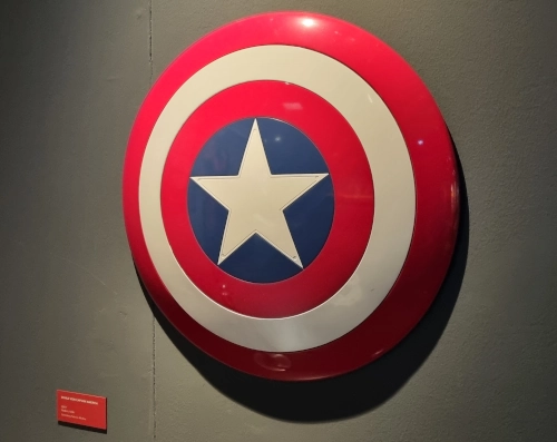 Der Schild von Captain Amarica an einer Wand, daneben eine kleine Museumsinfotafel