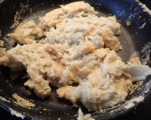 Linsenrührei in einer Pfanne, die Masse hat sich von der Pfanne gelöst und es sind schon einige angebräunte trockene Stellen zu sehen