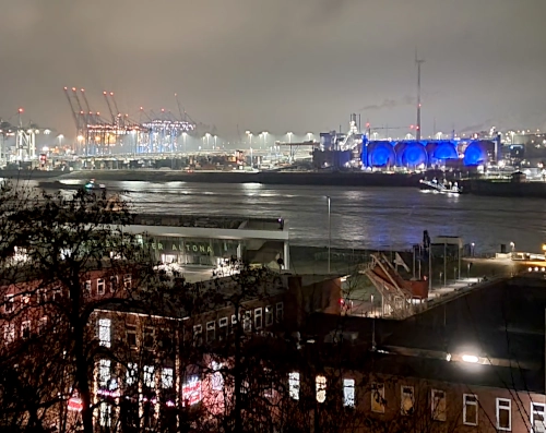 Der Hamburger Containerhafen bei Nacht, in weiß blau und rot glitzernd