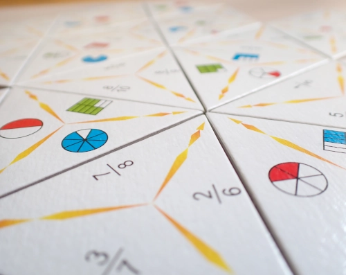 Nahaufnahme von einem Domino mit dreieckigen Teilen, auf denen Brüche aufgedruckt sind.