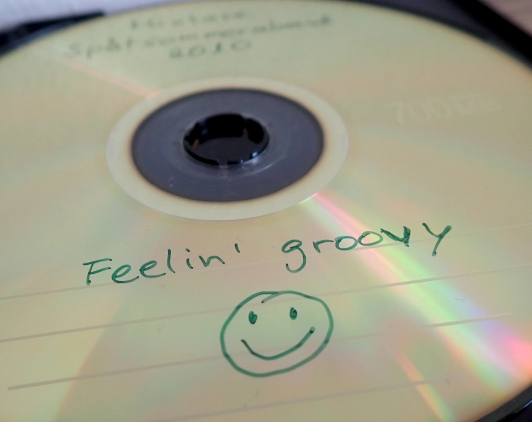 Nahaufnahme einer selbstgebrannten CD mit der Aufschrift Mixtape Spätsommerabend 2010, Feeling Groovy und einem fröhlichen Smiley